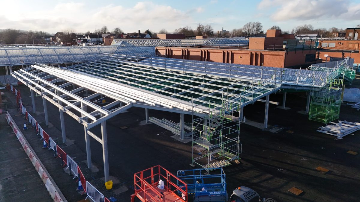 Close view of galvanised steel portal frame with cross-bracing during canopy erection
