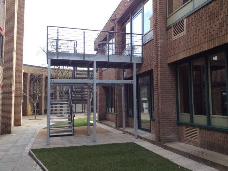 Galvanised steel fire escape with access platform and staircase fitted to a brick school building